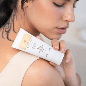 Mujer joven usando protector solar eco natural aruná de pantalla fisica
